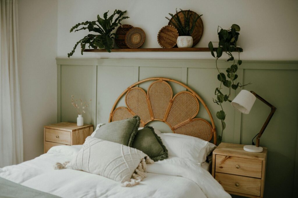 A warm Scandinavian bedroom featuring natural wicker decor and lush green plants.
