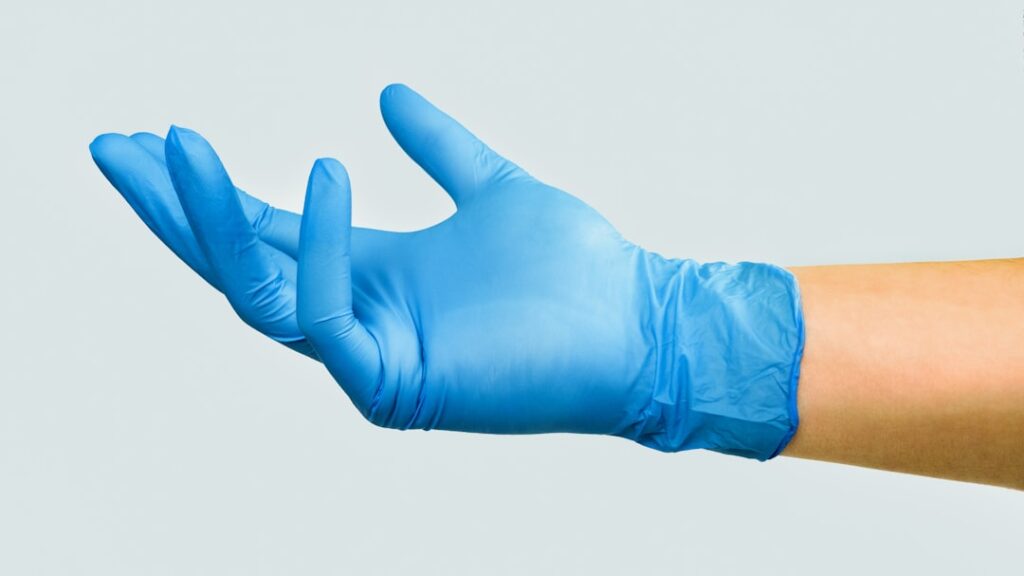 A hand in blue medical glove