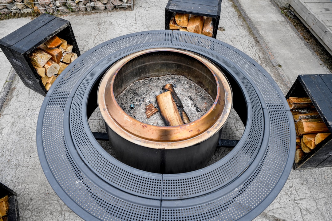Nordic Coziness: A modern circular outdoor fire pit with stacked firewood at Iglupark in the Noblessner district of Tallinn, Estonia.