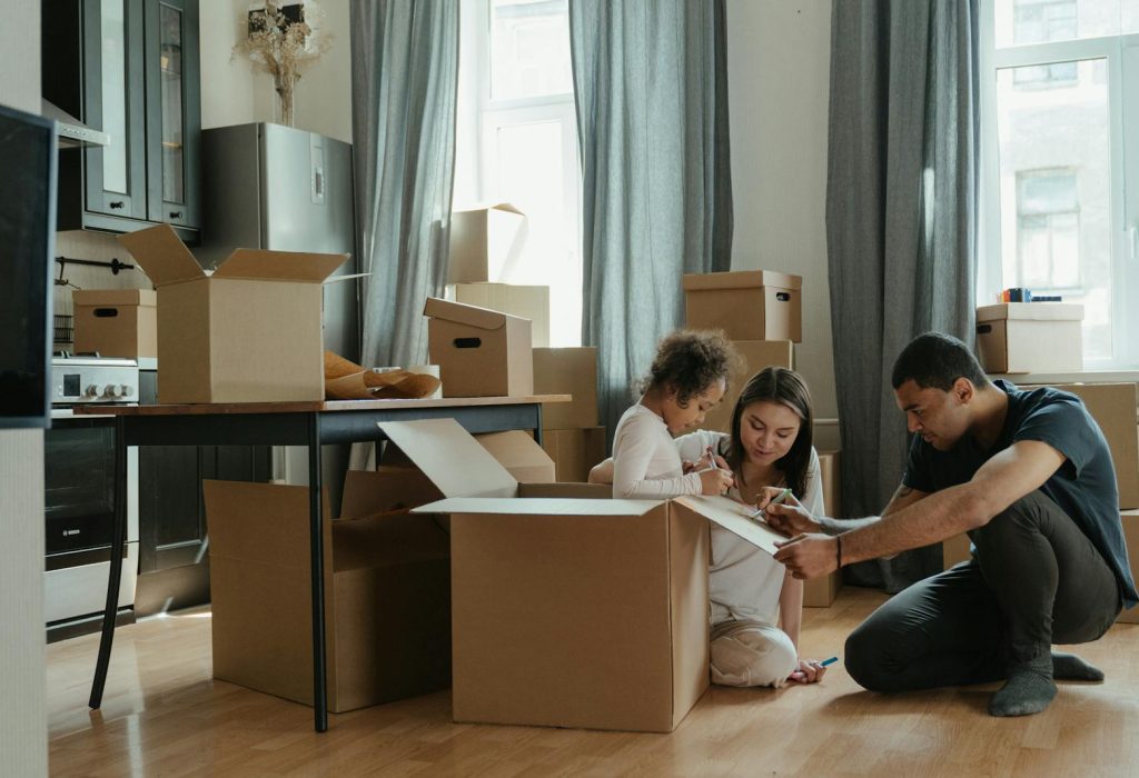 A family unpacks moving boxes in their new home kitchen, creating a cozy atmosphere.